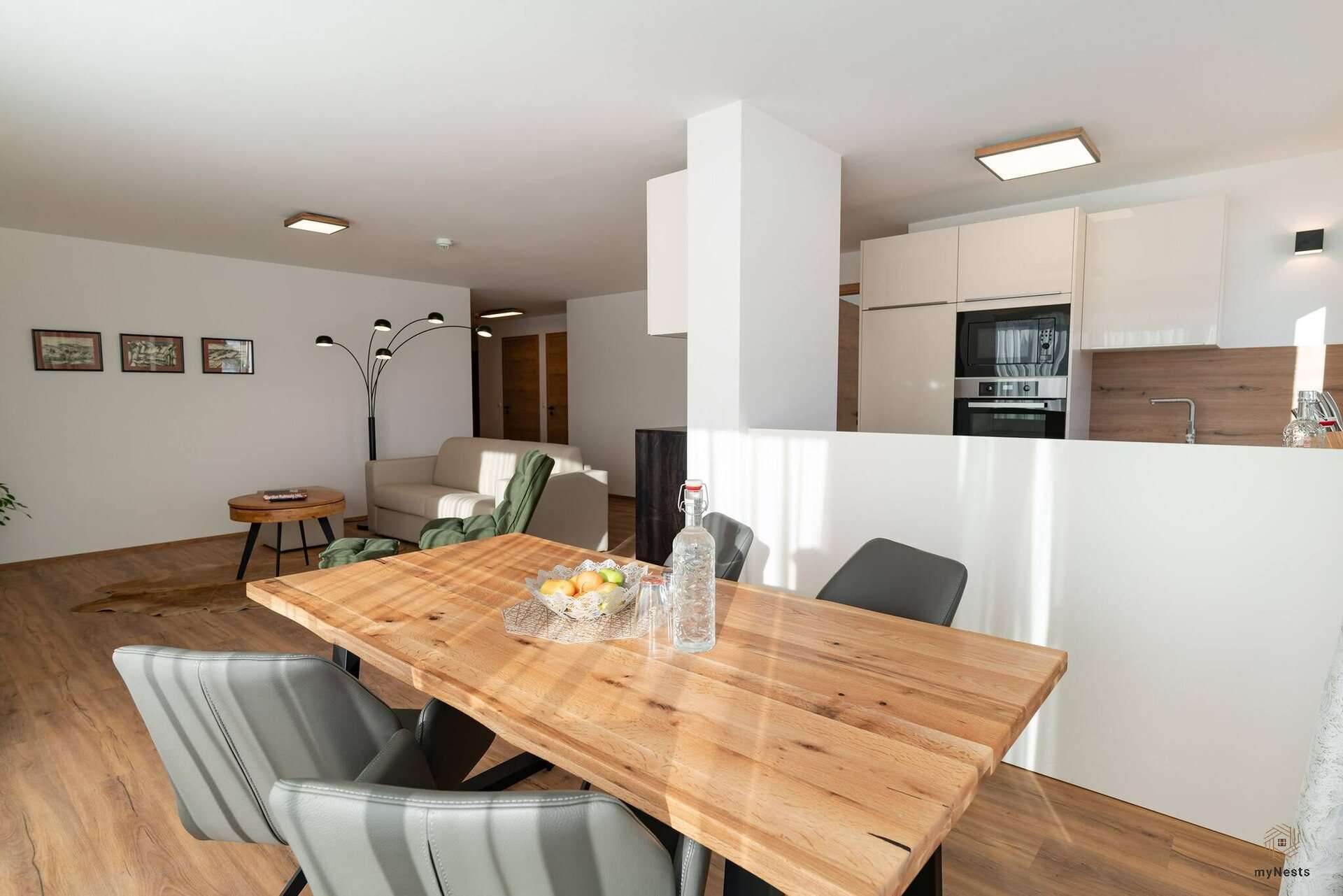 Dřevěný jídelní stůl se židlemi před kuchyní v apartmánu Bachstelze 10