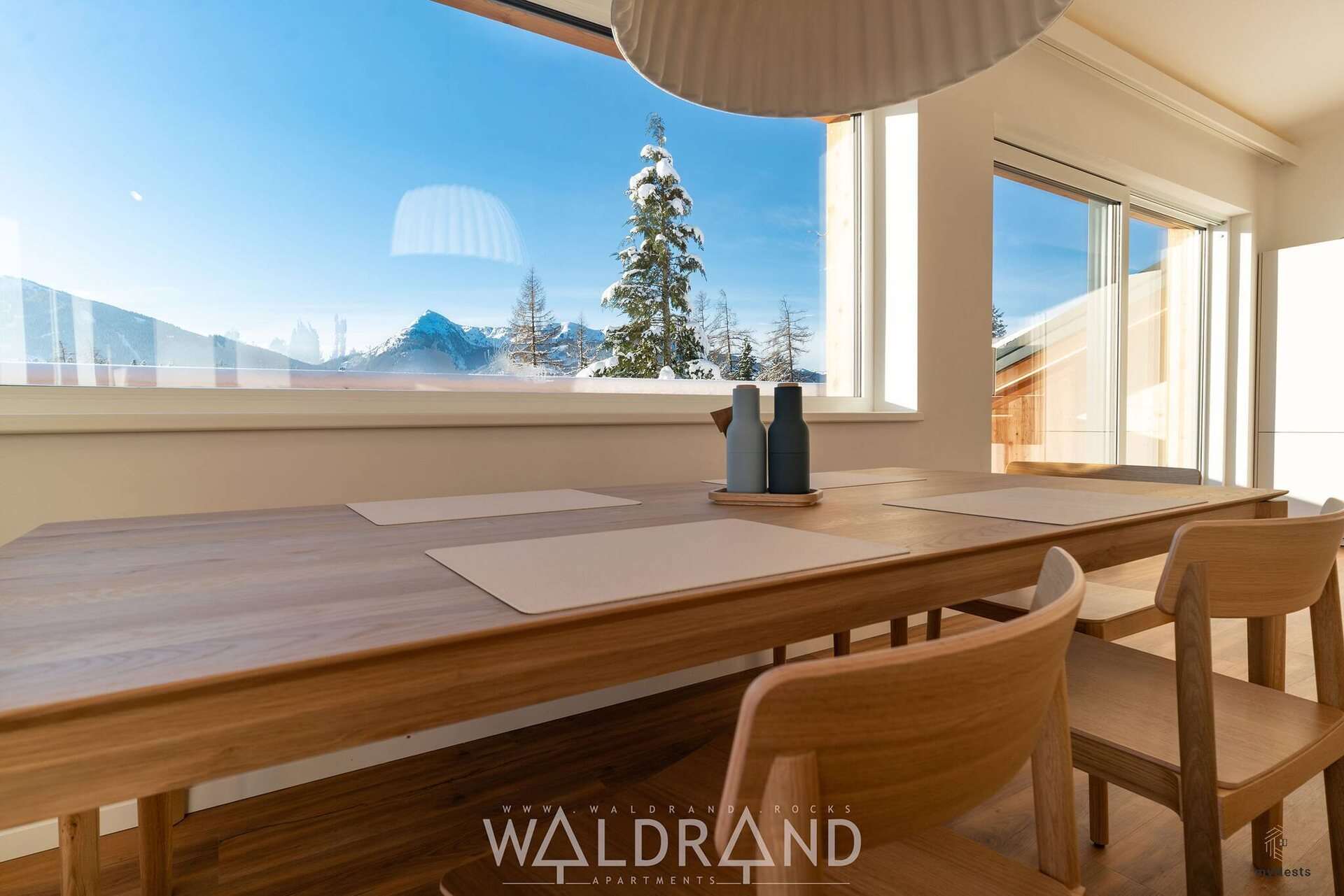Esstisch vor Fenster mit Blick auf verschneite Berge im Penthouse Falke 13