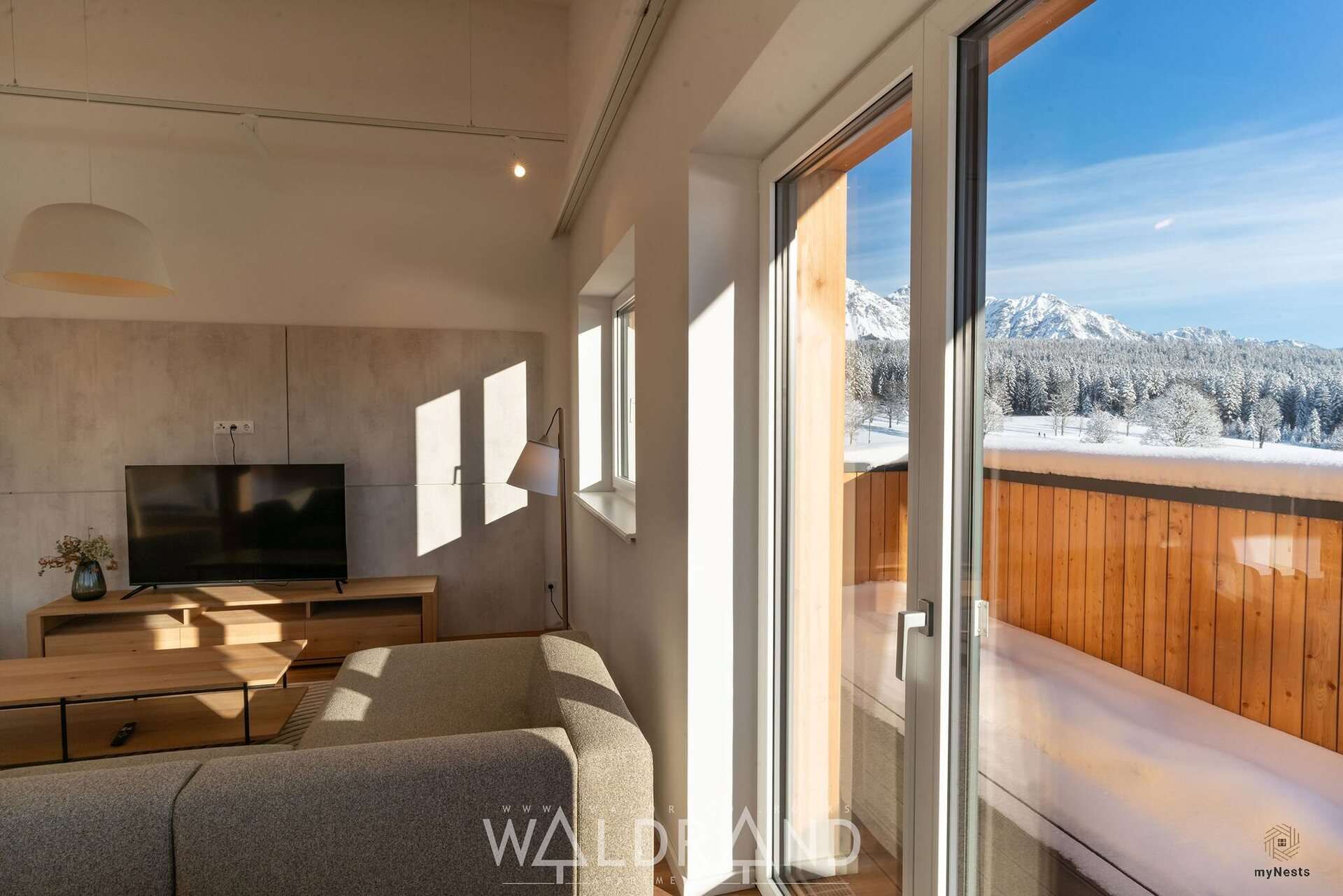 Wohnbereich mit Fernseher und Tür zur Terrasse im Penthouse Falke 13