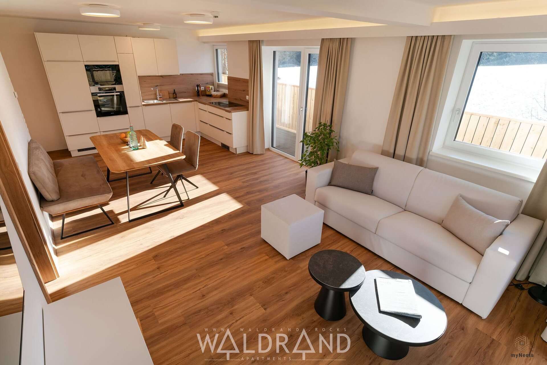Wohnbereich mit Sofa, Beistelltisch und Küche im Apartment Kuckuck 7