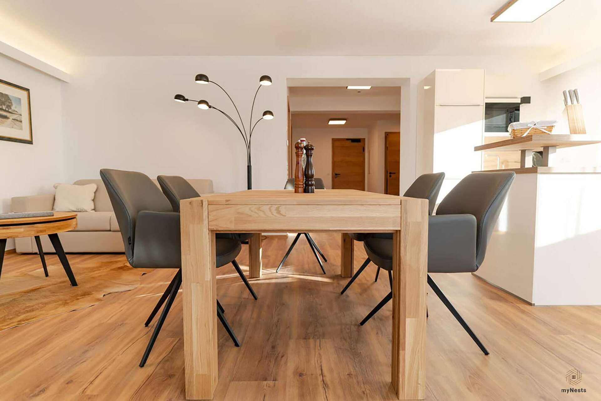 Dřevěný jídelní stůl se židlemi před kuchyní v apartmánu Lerche 4