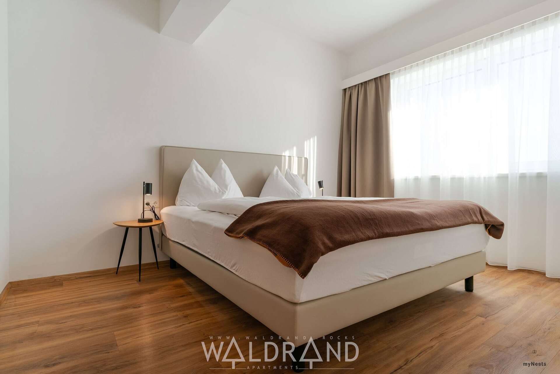 Ložnice s manželskou postelí a nočním stolkem v apartmánu Spiegelmeise 2