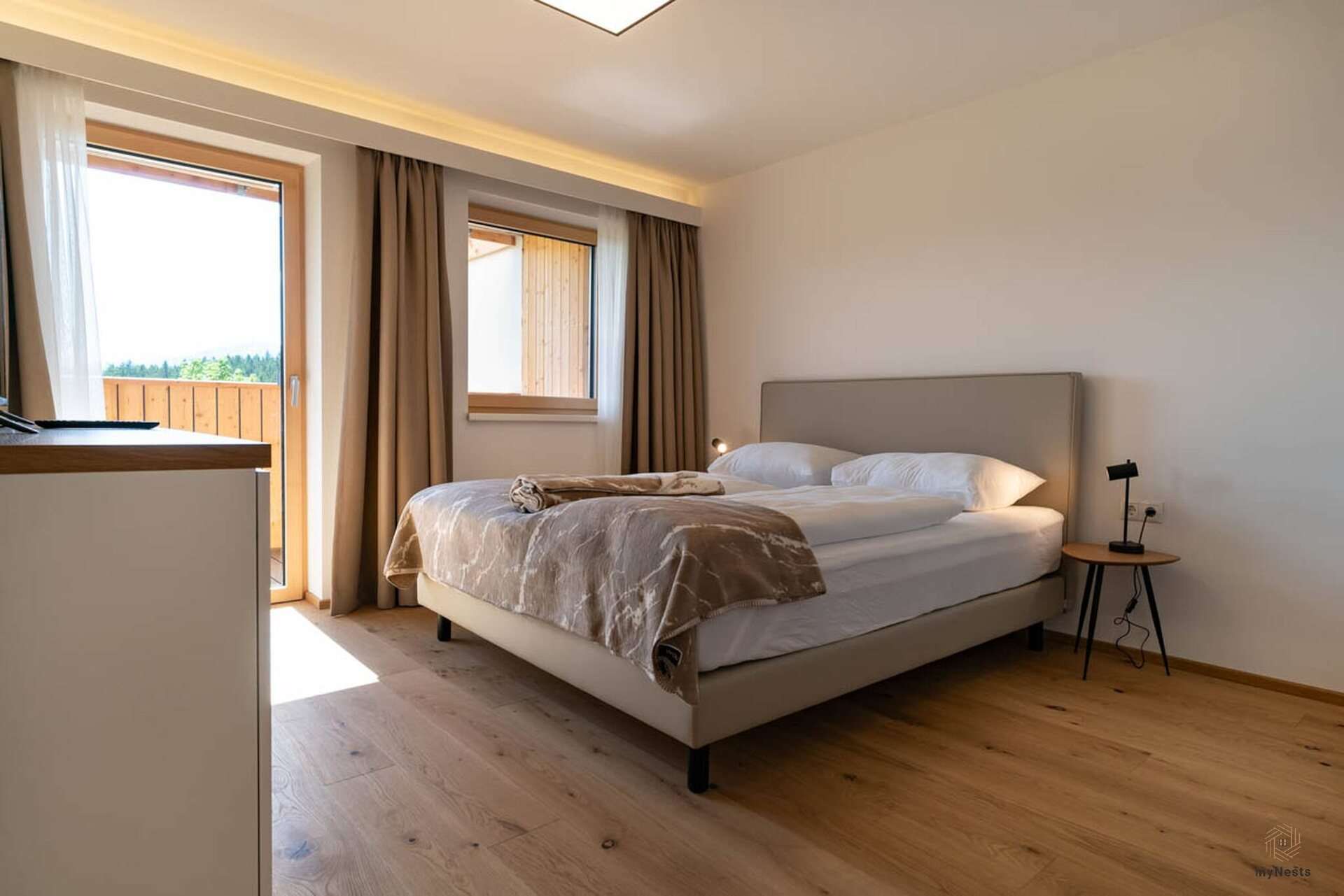 Ložnice s manželskou postelí a balkonovými dveřmi v apartmánu Zaunkönig 9