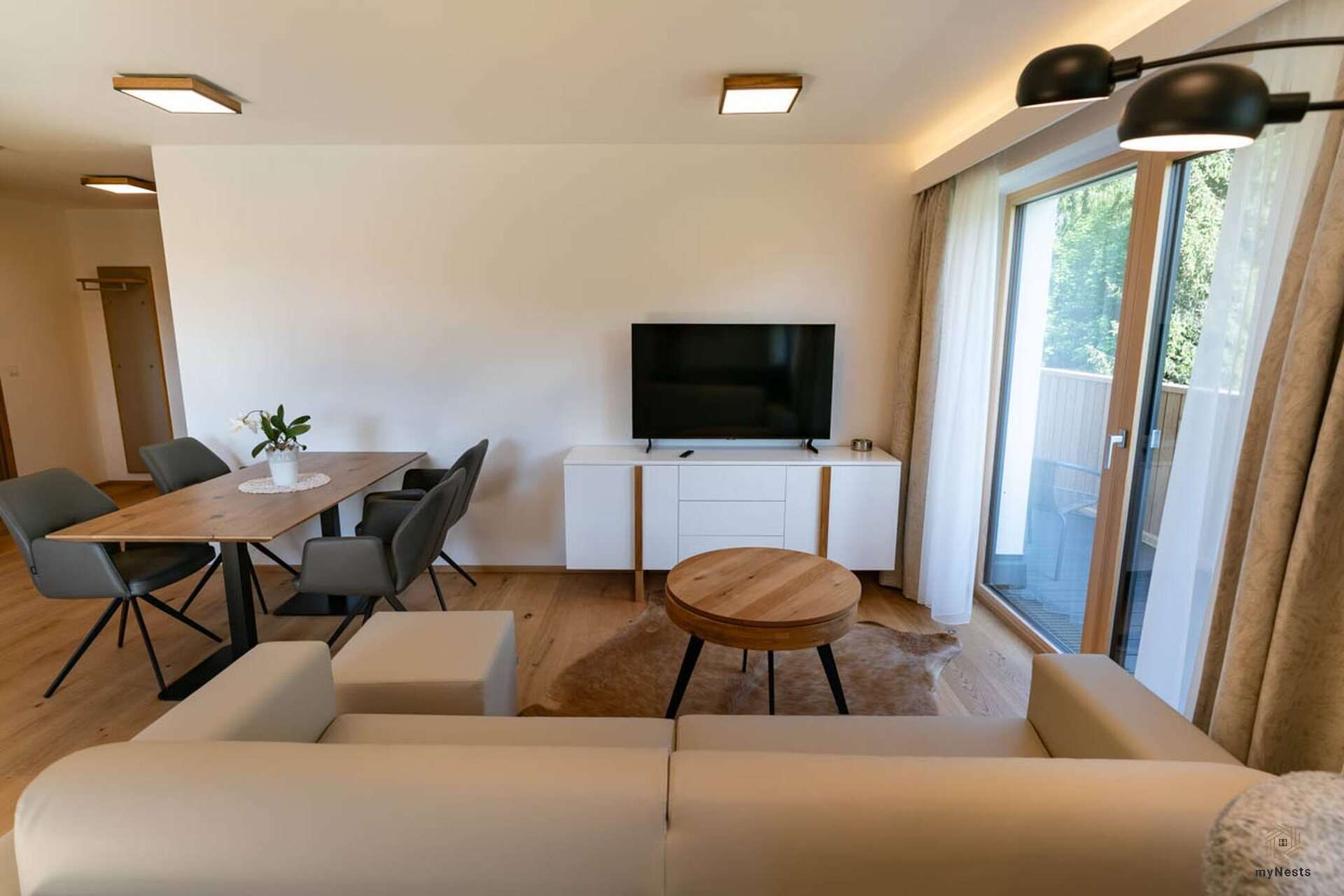 Obývací část s pohovkou, konferenčním stolkem a jídelním koutem v apartmánu Zaunkönig 9