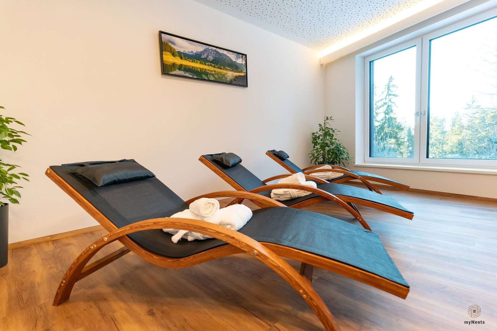 Odpočívárna ve wellness s dřevěnými lehátky a velkými okny